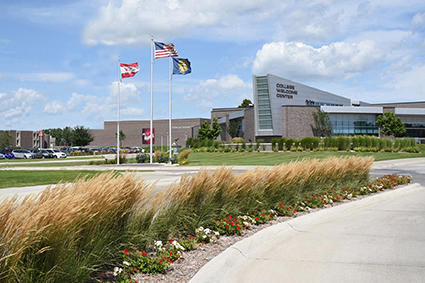 A view of the entrance to campus with a view of flags flying in front of the student center.