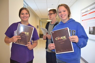 Students show off their laboratory books for camp