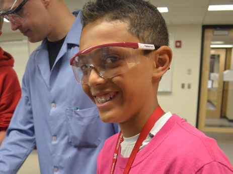 student with safety glasses on smiling