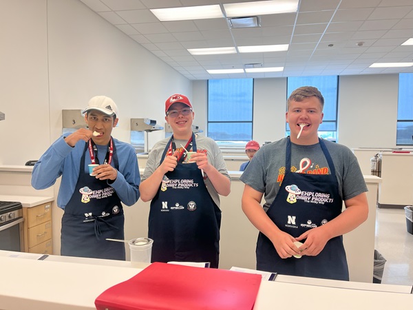 Three campers pose while tasting their ice cream in the teaching kitchen.