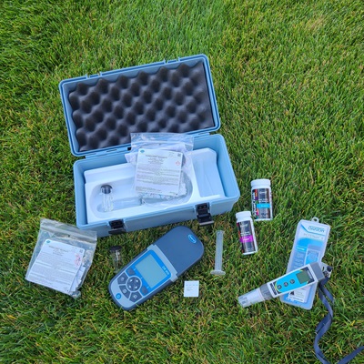 Water testing supplies including test strips, pH meter, and a portable spectrophotometer.